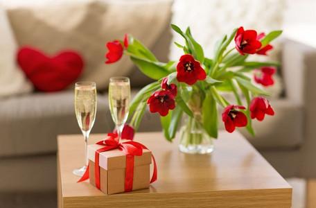 情人节和浪漫的概念-礼品盒,香槟酒杯和桌上的鲜花.花卉玫瑰花